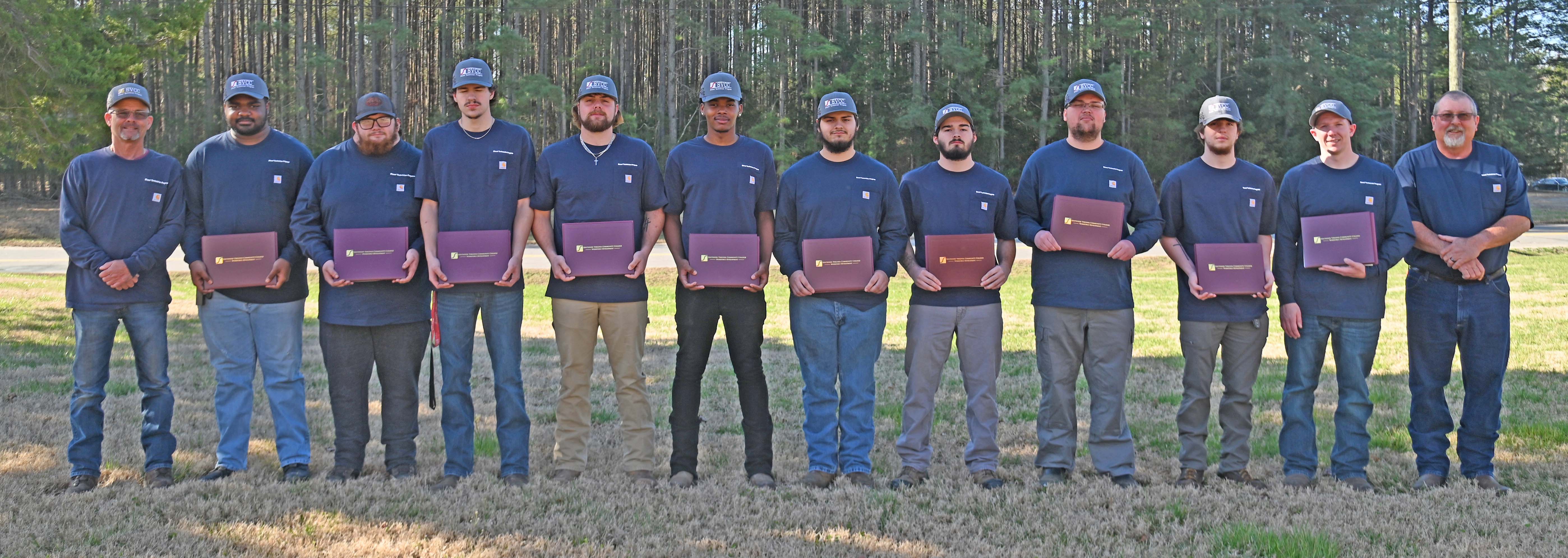 line of graduates holding certificates