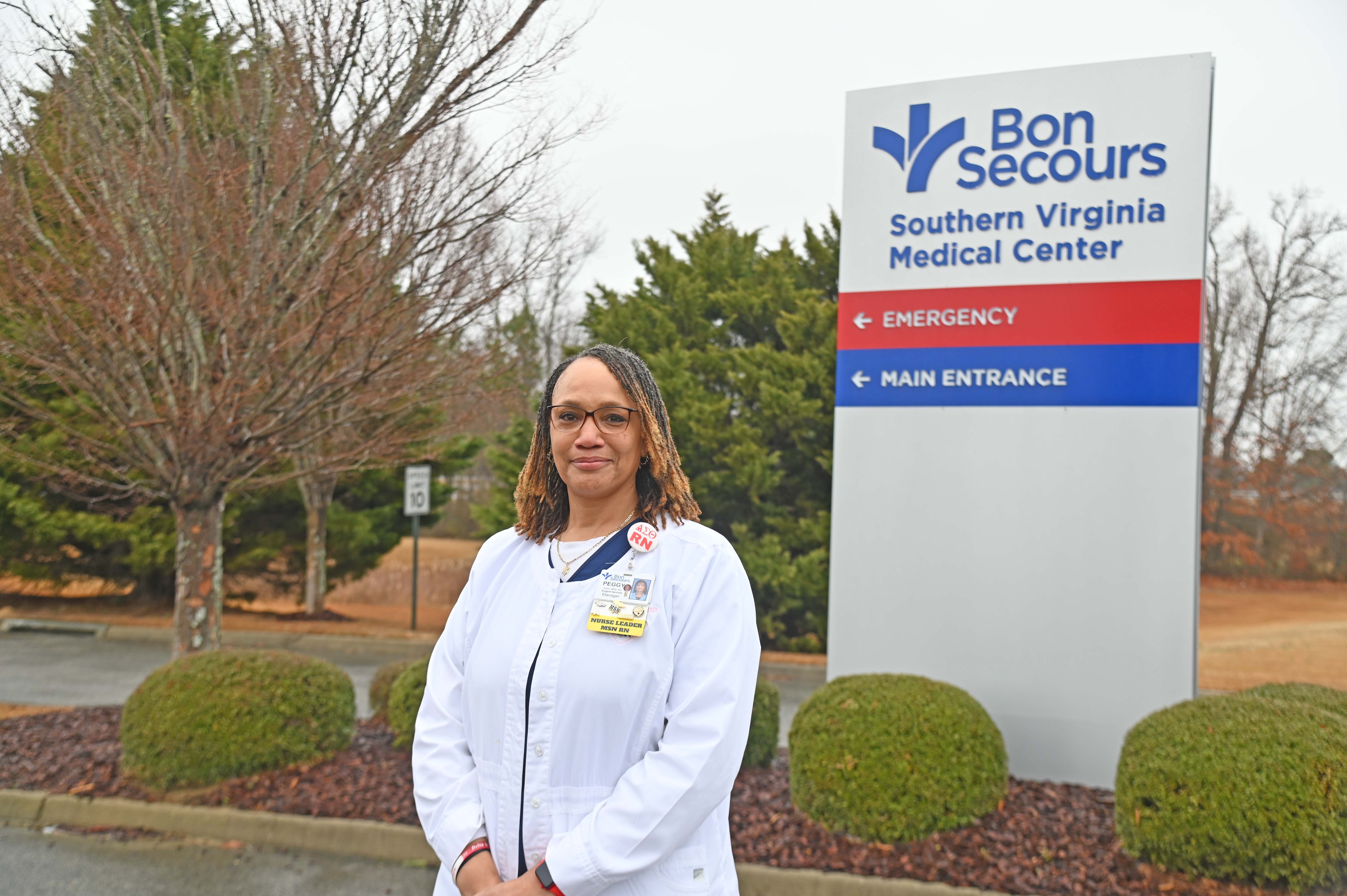 Nursing Alumna Peggy Dunn in front of Bon Secours sign