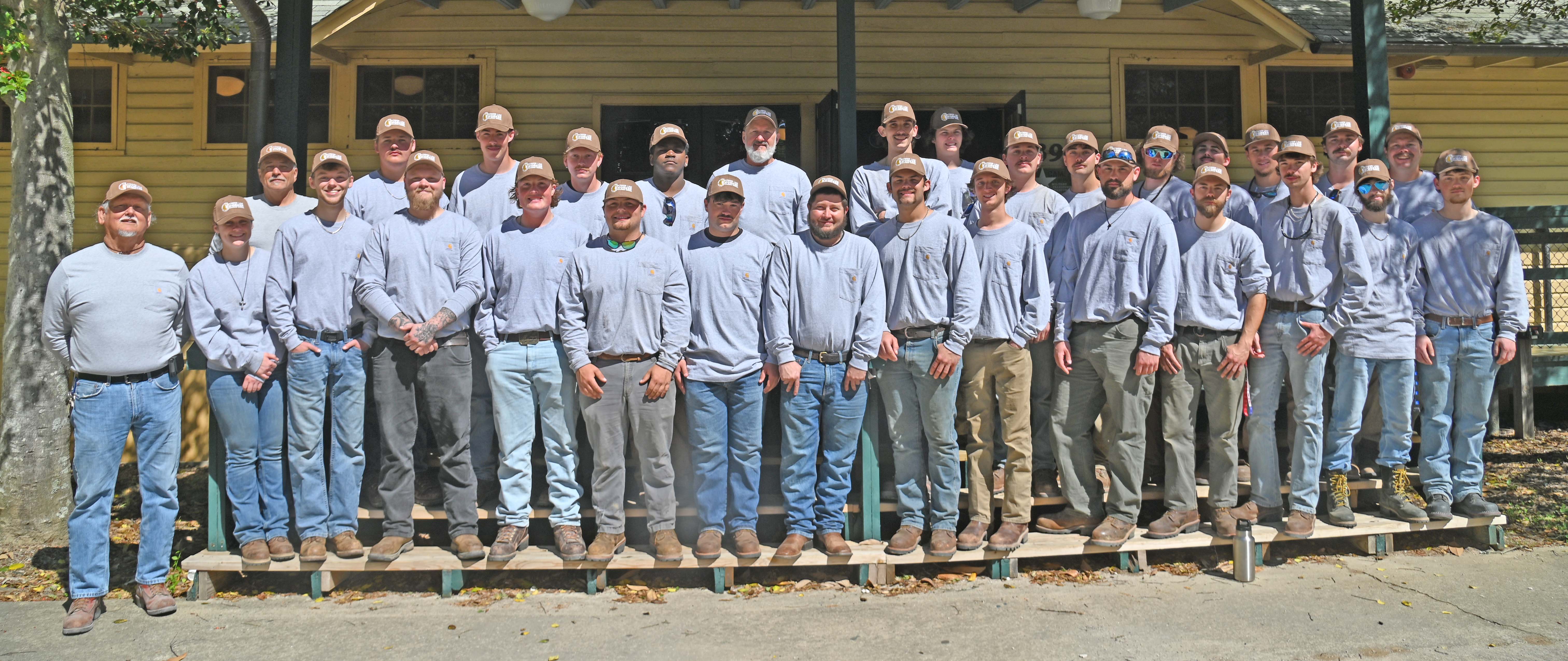 Picture of large group of Power Line graduates standing on the porch of a building
