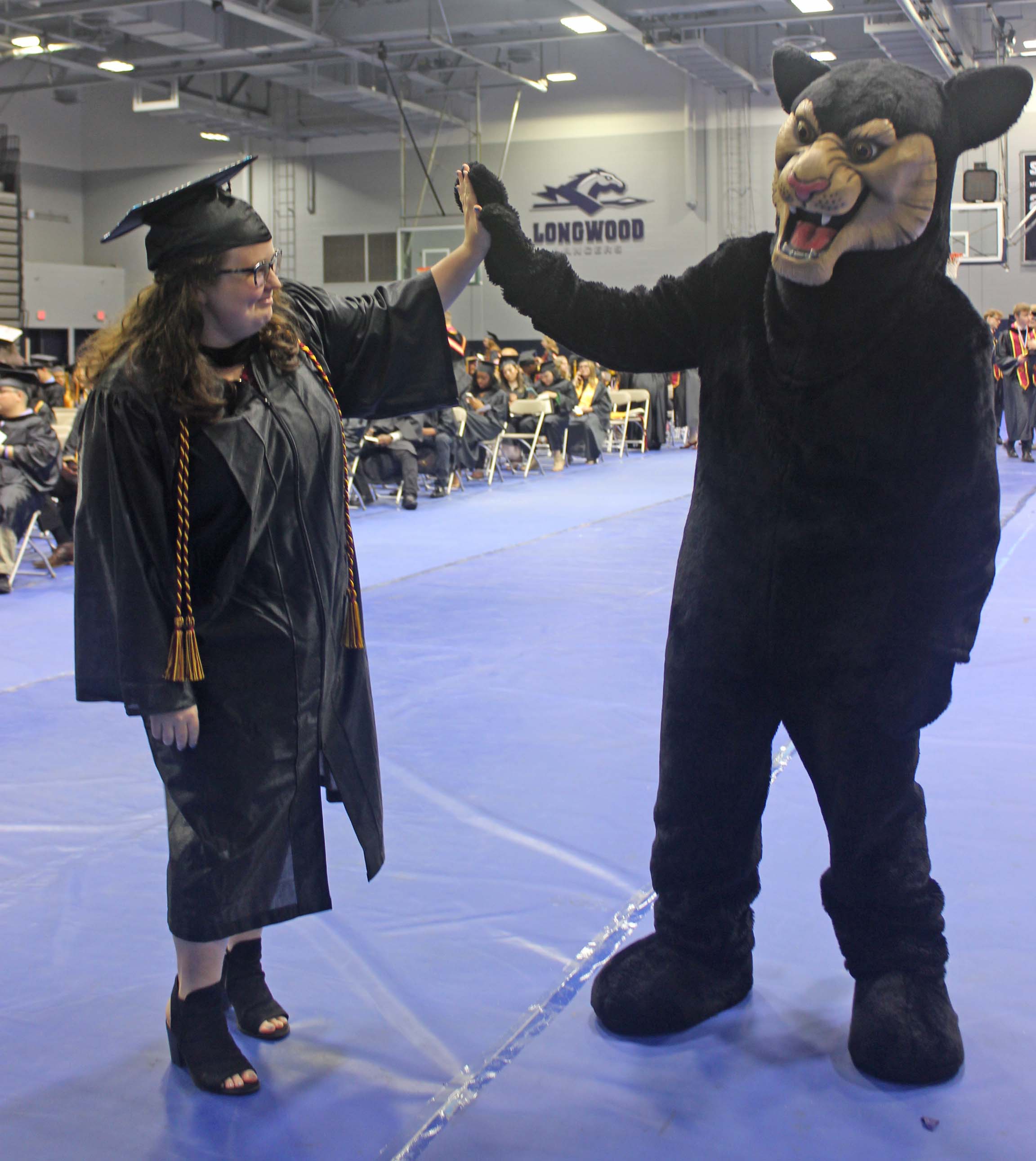 Elizabeth Farrell high fives Johnny Paws mascot in Longwood gym at SVCC graduation 2025